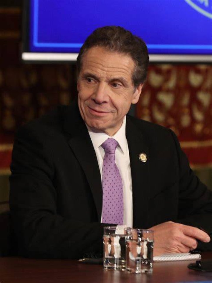 A photo shows Cuomo smirking with a staffer