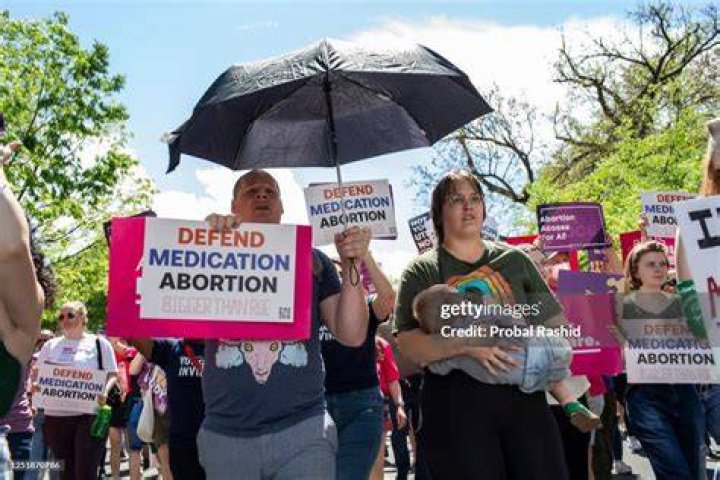 Abortion rights activists shout slogans.