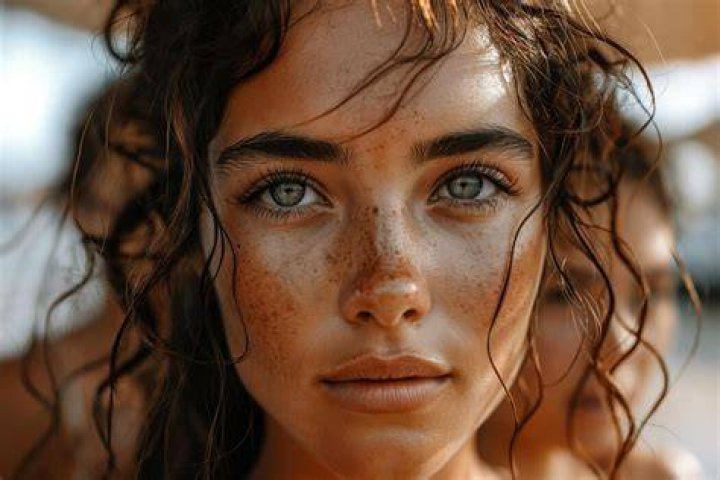 Close-up of a woman face divided in two parts - no retouch with red skin and acne and good beauty retouch.