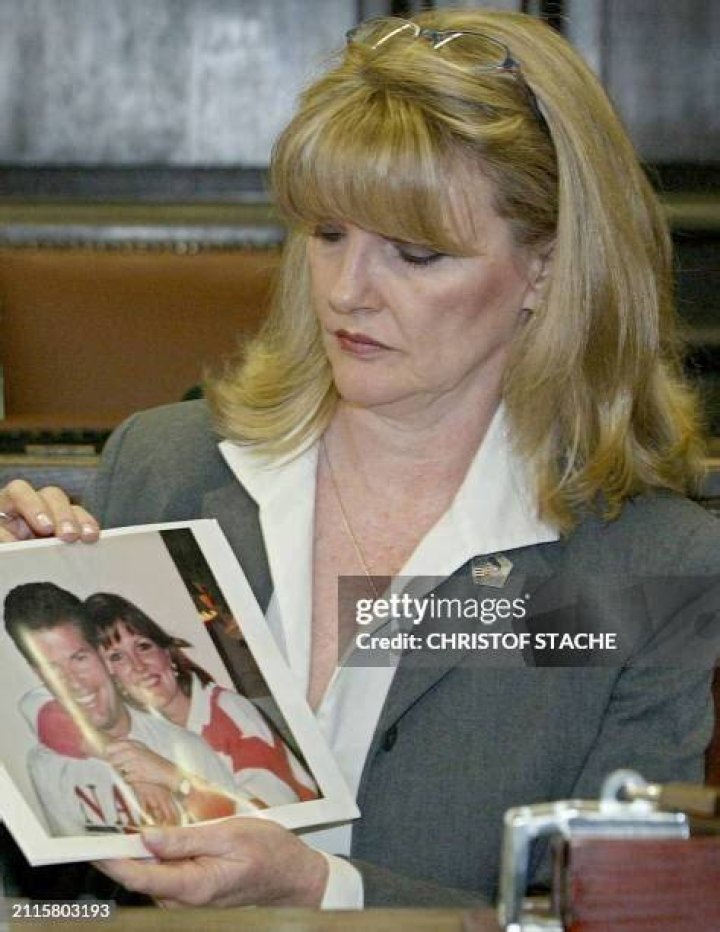 Debra Burlingame holding a photo of her brother Charles Burlingame, who was a pilot for American Airlines Flight 77
