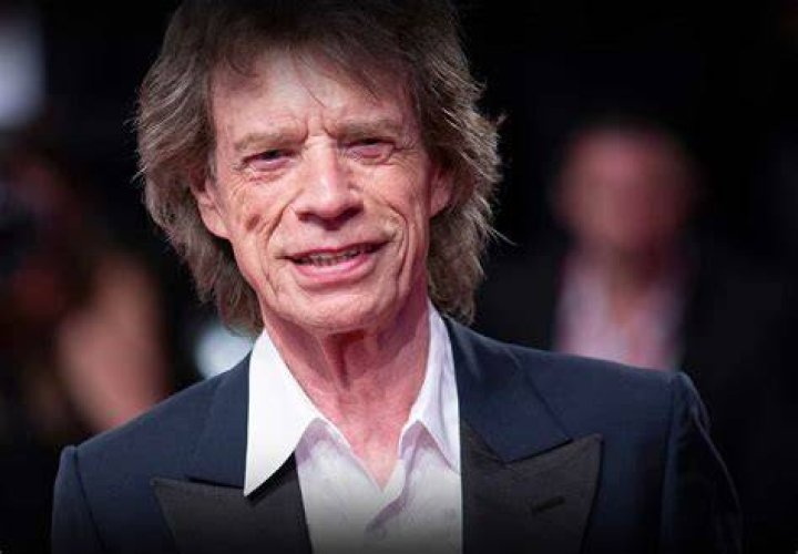 Mick's hand on his chest suggests he wants to be the centre of attention