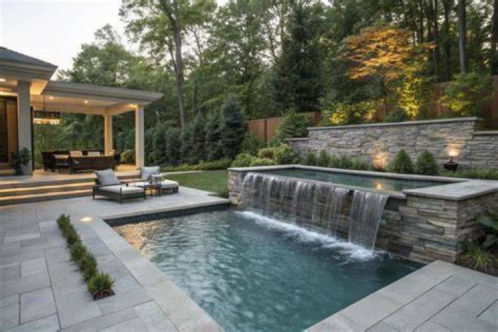 The backyard features a pool, waterfall, jacuzzi and BBQ area