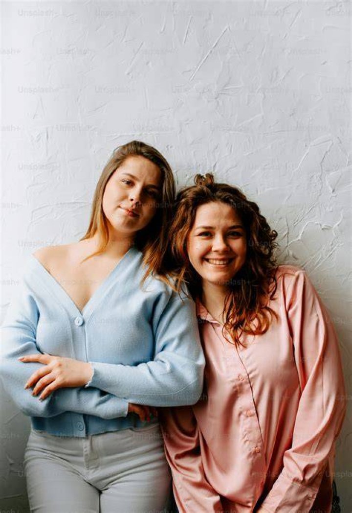 two women standing next to each other in front of a green wall with the words cmt music awards on it